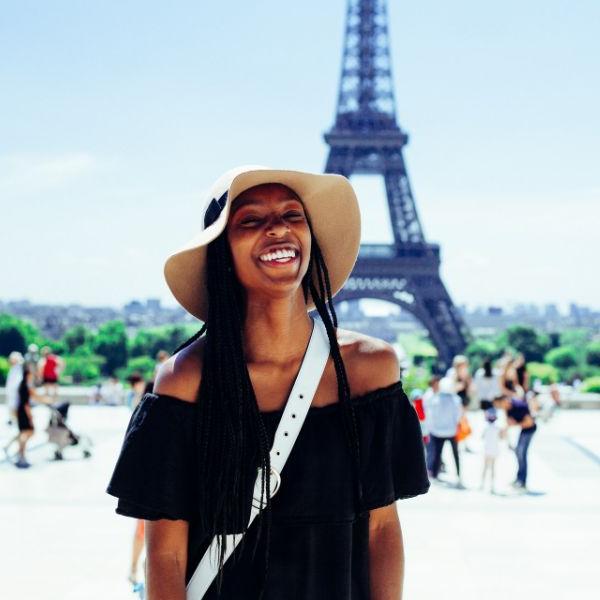 woman smiling in front of eiffel tower