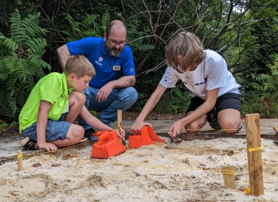 Instructor and campers digging in summer camp