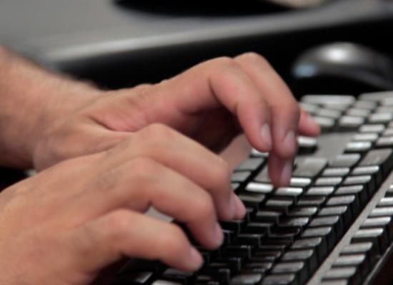 man typing on a keyboard in online course